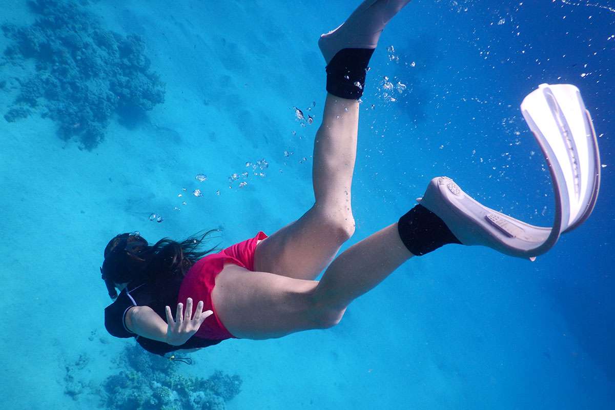 snorkeler wearing white snorkeling fins
