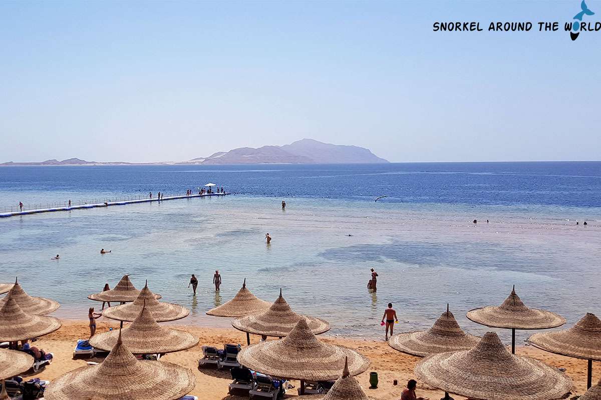 beach with people in Ras Nasrani with Tiran Island in the background